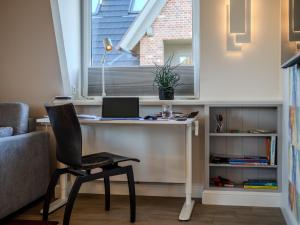 a desk with a laptop and a chair in a room at Haus Svenja in Westerland (Sylt) +46 photos