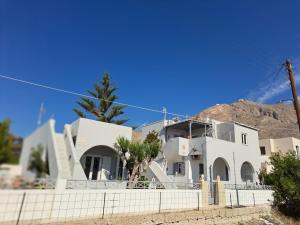 a white house with a mountain in the background at Κυκλαδίτικο σπίτι με θέα Villa Mimika in Perissa