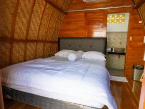 MantaakLumbung Lodge Lovina的一间木墙房间里的一张大床