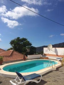 洛斯利亞諾斯德亞里達內的住宿－Casa Óscar，蓝色的游泳池,配有椅子和椅子