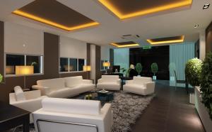 una sala de estar con sofás blancos y una mesa. en Hallmark Crown Hotel en Melaka