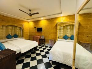 a bedroom with two beds and a checkered floor at Hostel sakura Jaisalmer in Jaisalmer