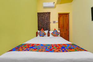 a bedroom with a bed with a colorful comforter at FabHotel Martine's Residency - French Colony, 5 Mins from Rock Beach in Puducherry