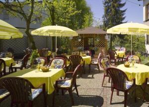 ein Restaurant im Freien mit Tischen, Stühlen und Sonnenschirmen in der Unterkunft Hotel Schoch in Mainhardt
