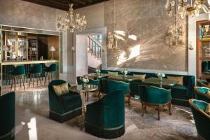 a restaurant with green chairs and tables and a bar at Hotel Gabrielli Venezia - Starhotels Collezione in Venice
