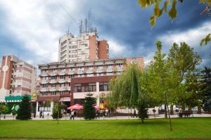 a large building with a park in front of it at Hotel Gorj in Târgu Jiu