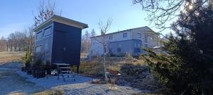a blue house with a black shed in front of it at Boží maringotka in Humpolec