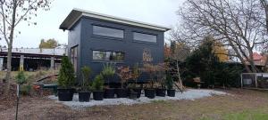 a tiny house with potted plants in front of it at Boží maringotka in Humpolec
