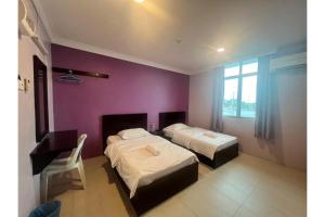 玻璃市港口OYO 91259 Hai Thien Motel的一间卧室设有两张床和紫色墙壁