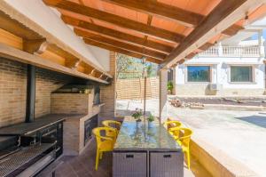 a patio with a table and chairs and a grill at YourHouse Can Marques villa in Palma de Mallorca