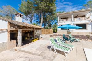 a patio with chairs and a grill and a house at YourHouse Can Marques villa in Palma de Mallorca