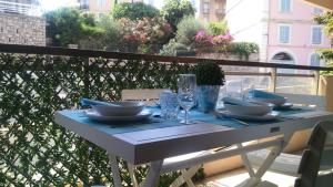 une table blanche avec des assiettes et des verres sur un balcon dans l'établissement Appartement proche mer et gare, à Cannes