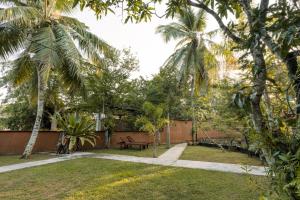 Villa Sri Ceylon في Habaraduwa Central: حديقة بها مقاعد و نخيل