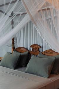 Villa Sri Ceylon في Habaraduwa Central: غرفة نوم بسريرين مع ستائر بيضاء