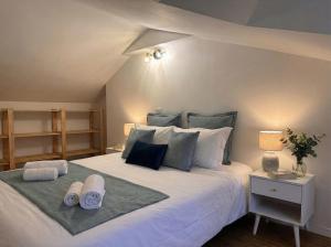 a bedroom with a large white bed with towels on it at Logis du Mousquetaire -15min du Parc - by R&G in La Pommeraie-sur-Sèvre