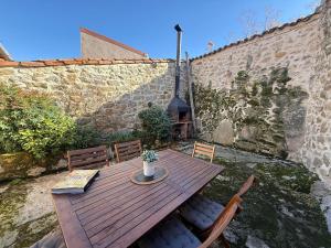 une table en bois avec des chaises et une plante en pot dans l'établissement Casa rural Fuente Santa, à Medinilla