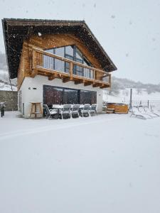 uma casa coberta de neve com uma mesa e cadeiras em Chata Myto em Mýto pod Ďumbierom