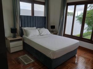 a bedroom with a large bed with a large window at Ntsudini 2 in Marracuene