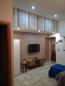 ein Wohnzimmer mit einem Flachbildfernseher an der Wand in der Unterkunft Panariello a Portamedina in Neapel