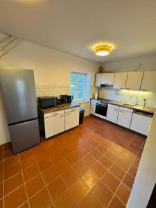 盖森费尔德Bavaria Home - Zentral, Küche, Waschen, Parken的厨房配有白色橱柜和瓷砖地板 更多10张照片