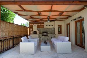 a patio with two chairs and a table and a kitchen at Beautiful Villa Pera with private pool and lovely gardens, Aphrodite Hills in Kouklia