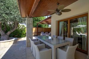 an outdoor patio with a table and chairs at Beautiful Villa Pera with private pool and lovely gardens, Aphrodite Hills in Kouklia