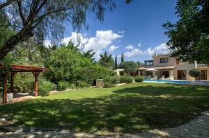 a large yard with a pool and a house at Beautiful Villa Pera with private pool and lovely gardens, Aphrodite Hills in Kouklia
