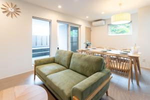 ein Wohnzimmer mit Couch und Küche in der Unterkunft Grandioso Okinawa Pool Villa Onna - Vacation STAY 52628v in Inbu