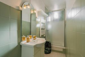 Un baño blanco con lavabo y ducha. en Fête des Lumières Lyon Séjour à Montluel, en Montluel