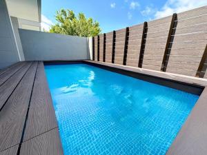 einem Pool vor einem Holzzaun in der Unterkunft Grandioso Okinawa Pool Villa Onna - Vacation STAY 52628v in Inbu