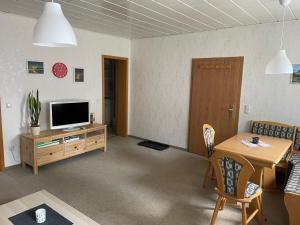 a living room with a television and a table at Ferienwohnung Furchner in Sayda