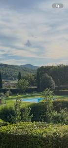 a swimming pool in a grassy field with trees at La terrazzina nel borgo apt dimora storica toscana pool&garden in Lano