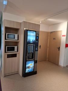 a video game vending machine in a room with a door at Unisotel Lyon Bron Eurexpo in Bron