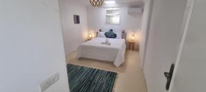 Una habitación blanca con una cama y una ventana en VILLA Malaika, en Marrakech