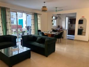 The Green Door في Lāndrān: غرفة معيشة مع أريكة وطاولة مع كراسي