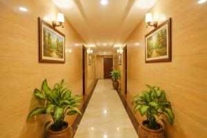 a hallway with two potted plants in a building at FabExpress Arunachala Guest House in Chennai