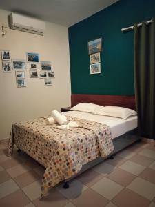 イニャンバネにあるHotel Bom Amigoのベッドと緑の壁のある寝室