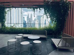 a patio with tables and chairs and a view of a city at Majestic Residence KLCC By Homestay in Kuala Lumpur