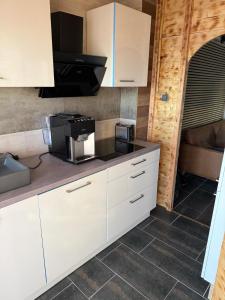 una cucina con mobili bianchi e un forno a microonde di Moderne 1-Zimmer-Ferienwohnung a Niederdorla