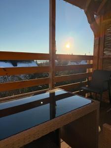 un tavolo di vetro su un balcone con vista sul tramonto di Moderne 1-Zimmer-Ferienwohnung a Niederdorla Altre 3 foto