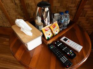 a table with two remote controls and a coffee maker at Lumbung Lodge Lovina in Balian