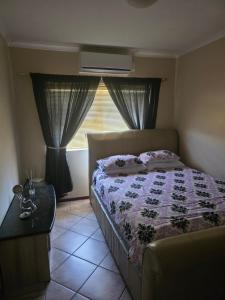 a bedroom with a bed and a window at Peters Place in Kuilsrivier +18 photos