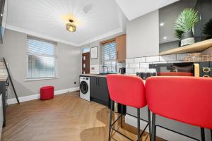 a kitchen with red chairs and a washing machine at Rosemont ApartHotel in Leeds