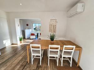 ein Esszimmer mit einem Holztisch und Stühlen in der Unterkunft Maison - Saint-Martin La Plaine - Loire in Saint-Martin-la-Plaine