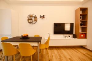 a dining room with a table and a flat screen tv at Le Rotte di Antonella in Lido di Ostia