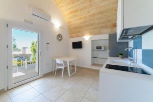 佩斯科勒海滨Villa Lantana by SALENTOLTREMARE的带桌子和台面的厨房 更多20张照片