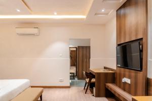 um quarto com uma cama, uma escrivaninha e uma TV em Treat Aranya Resort Kumbhalgarh em Kumbhalgarh