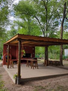 a wooden pavilion with tables and benches in a park at Cabañas Nueve Alamos in Casa Grande