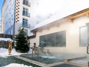 a swimming pool in the courtyard of a building at Schweizerhof Ferienwohnungen Lenzerheide Haus 3 in Lenzerheide