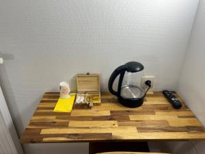 a table with a black tea kettle on it at Hôtel Arc-en-Ciel in Strasbourg